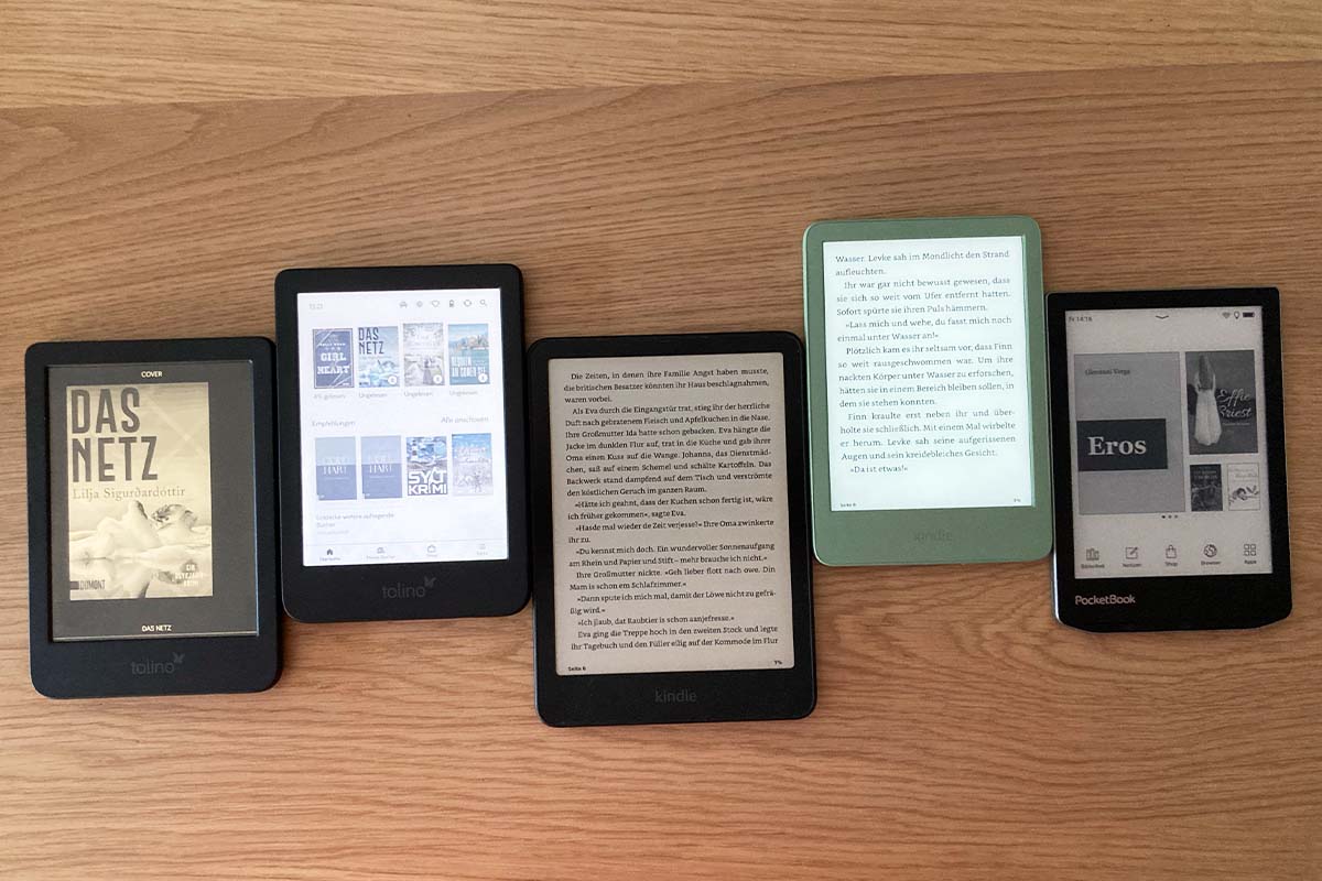 5 eBook-Reader auf einer Holzplatte liegend