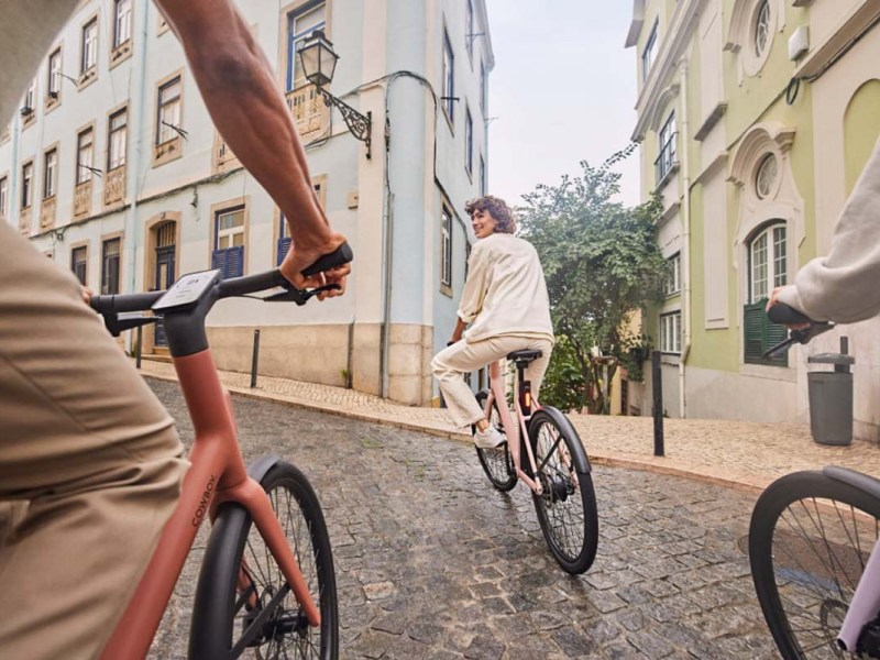 Drei Fahrradfahrer fahren mit ihren E-Bikes durch die Stadt