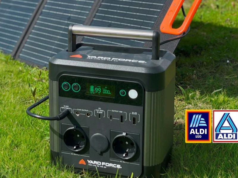 Powerstation auf einer Wiese stehend, dahinter ein Solarpanel, Aldi Logo mit im Bild