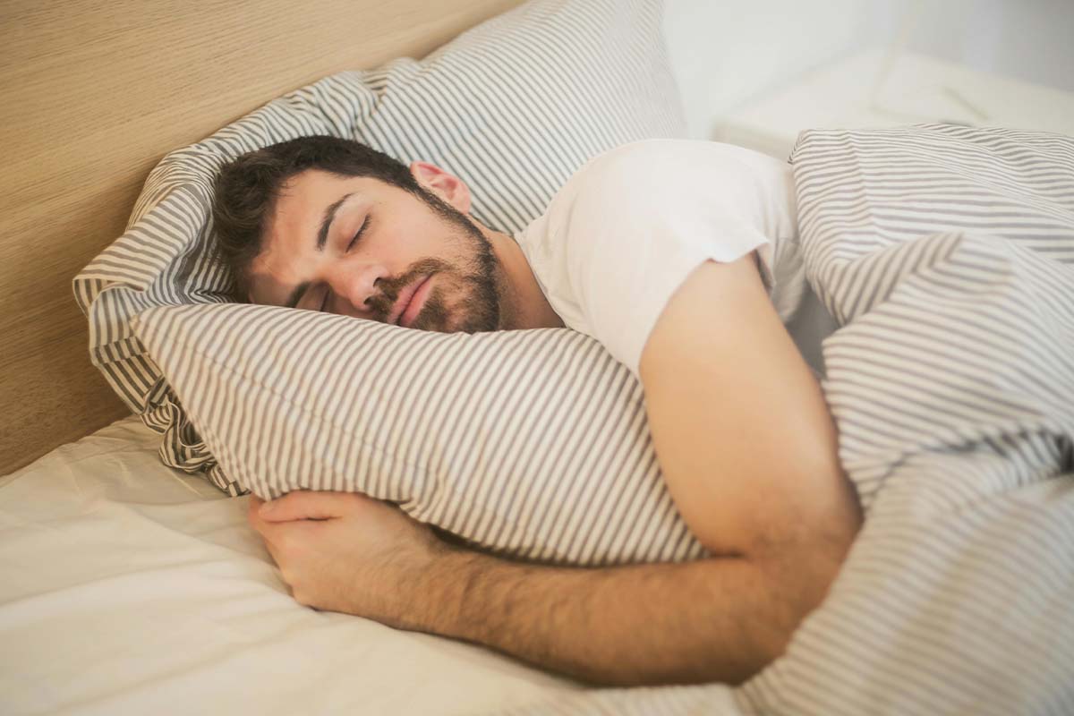 Nahaufnahme schlafender Mann in einem Bett