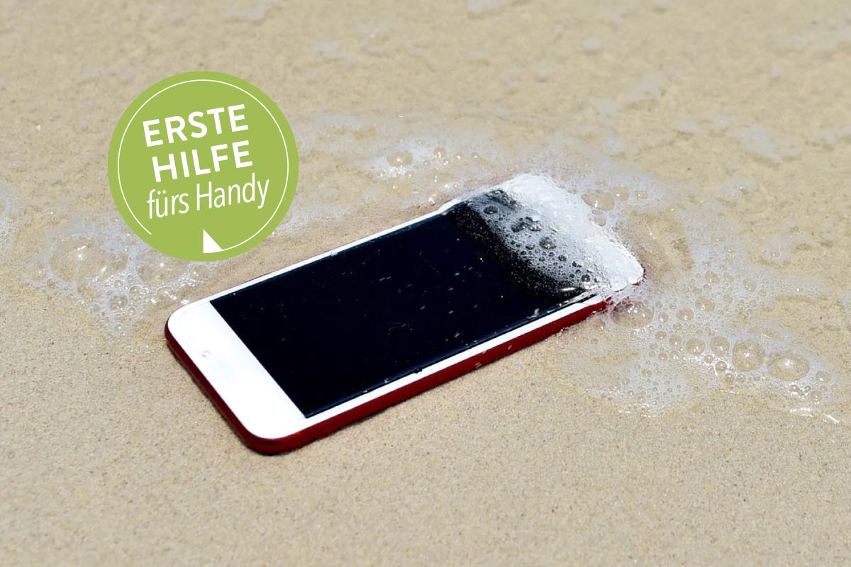 Smartphone liegt am Strand und wird von Meerwasser Ã¼berspÃ¼lt.