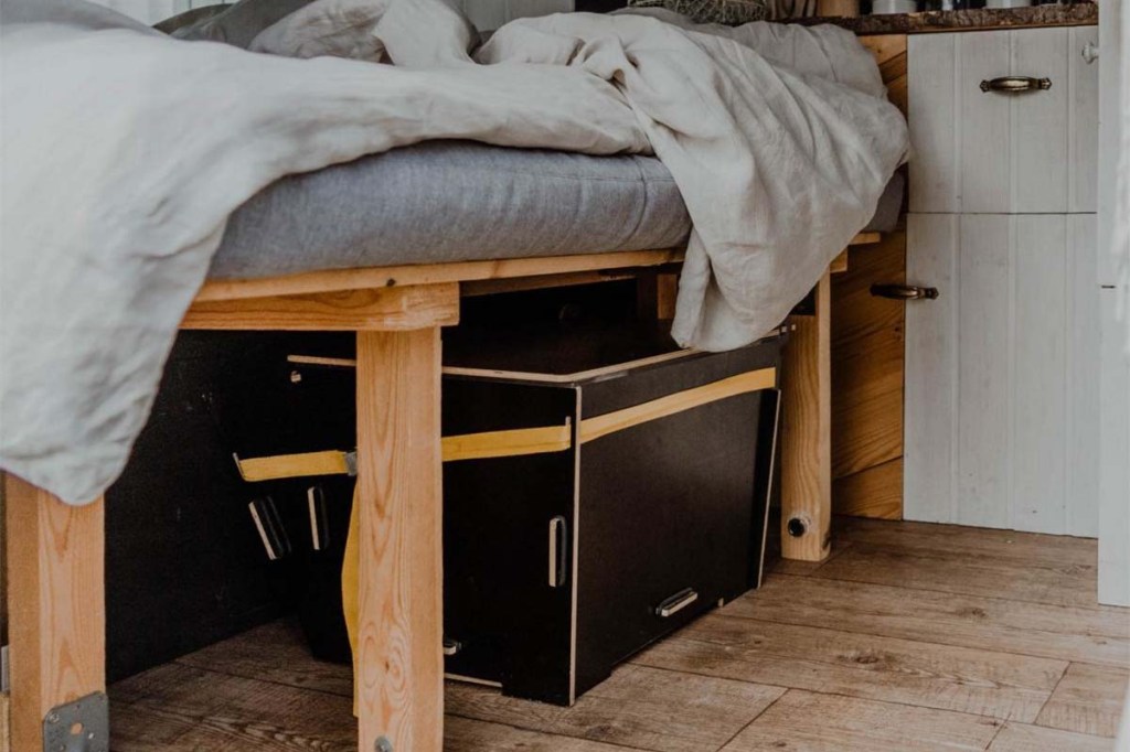 Trenntoilette unter einem Bett im Campervan stehend