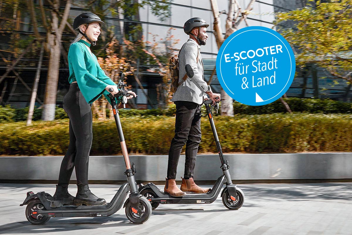 Personen auf einem E-Scooter.