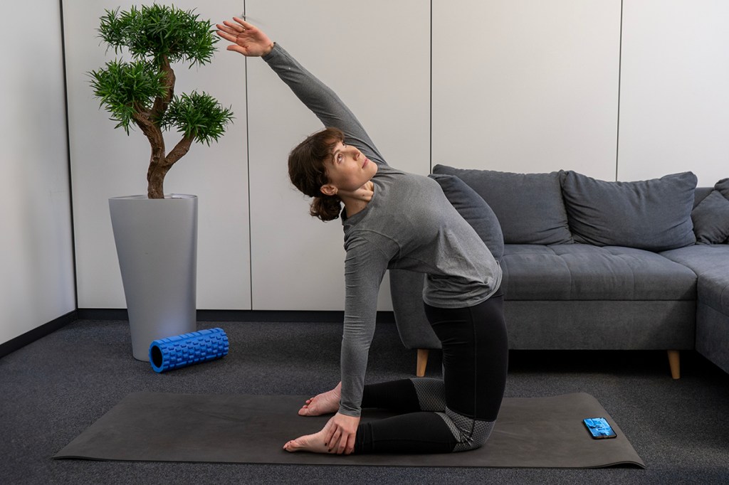 Eine Frau macht Yoga-Übungen auf dem Boden.