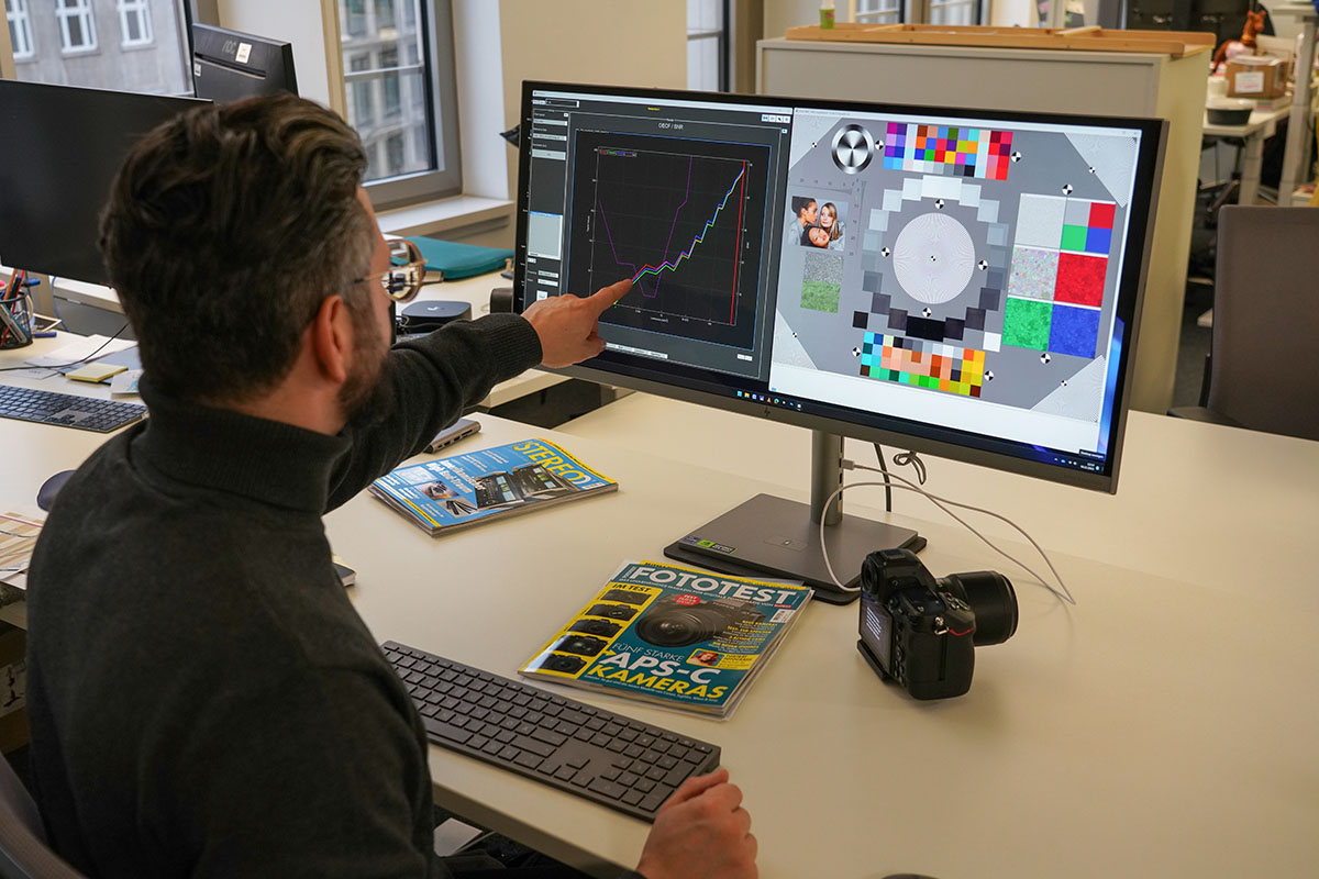 Mann sitzt vor zwei PC-Monitoren und bewerten anhand von einer Software die Qualität von Testfotos.