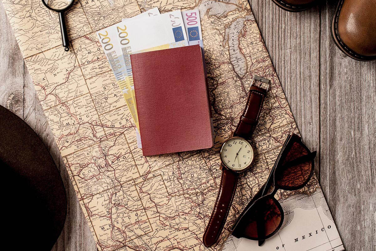 Ein Portmonnaie, eine Uhr und eine Sonnenbrille liegen auf einer Landkarte.
