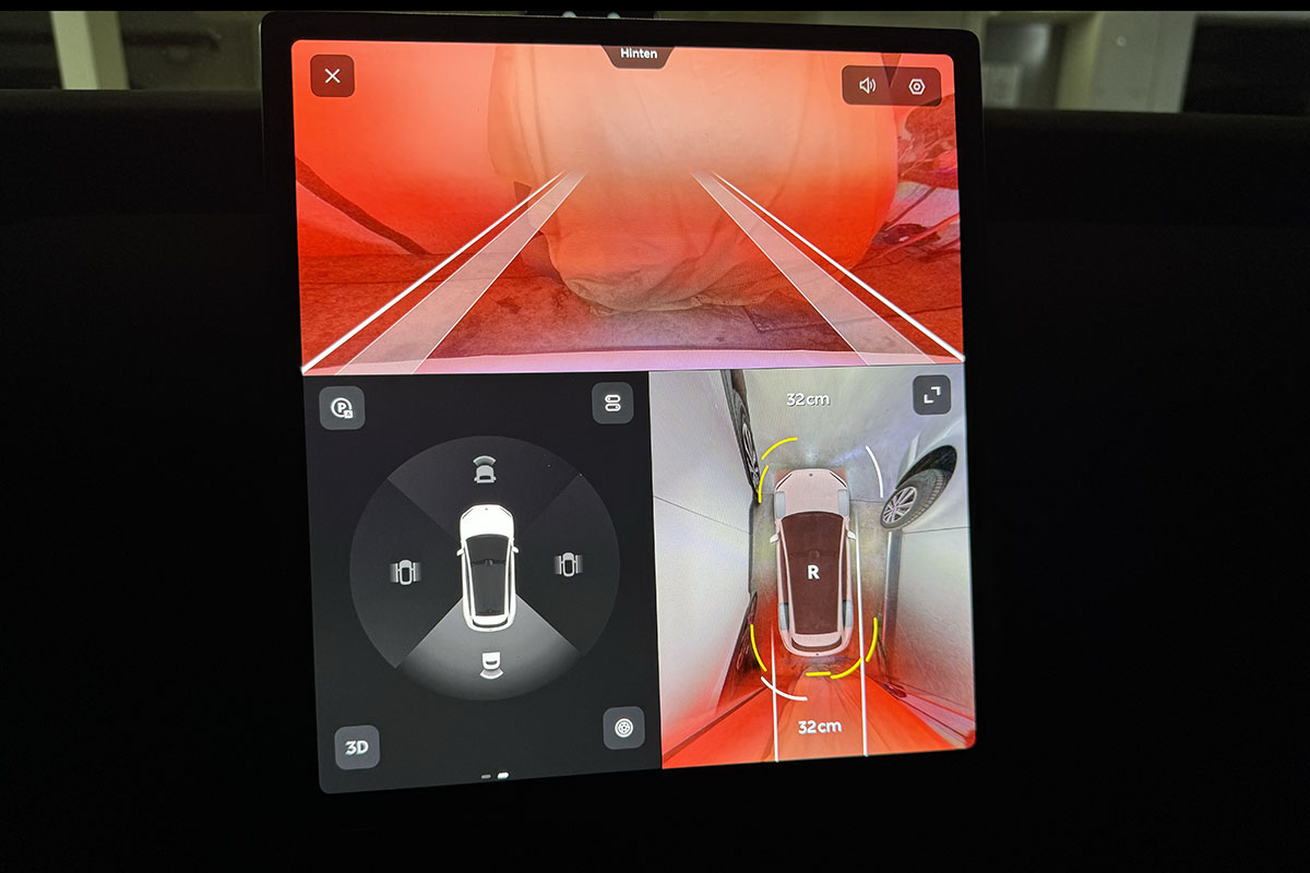 Blick auf das Infotainment-Display des E-Autos Nio ET5 Touring mit Anzeigen, die die Kameras des Autos beim Einparken liefern.