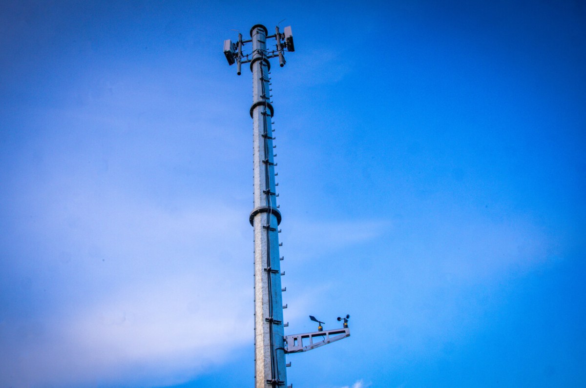 Ein Mobilfunkmast ragt in den blauen Himmel.