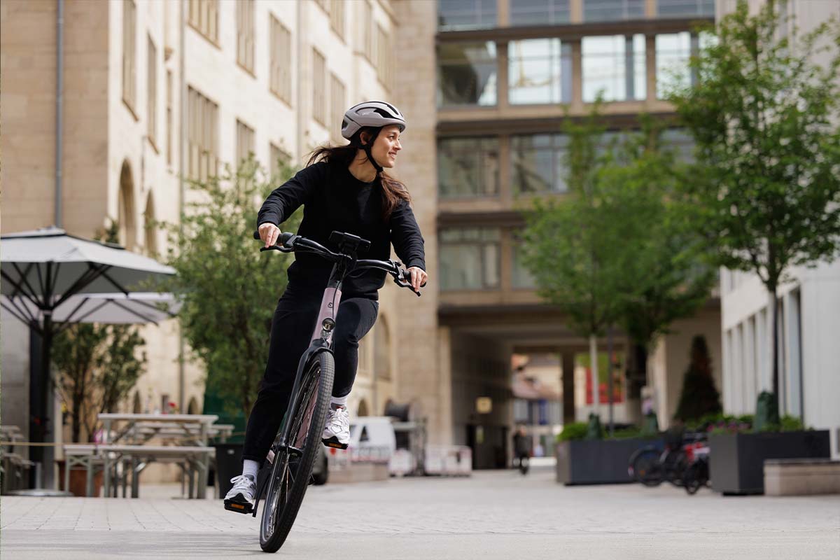 Frau fährt mit einem Fahrrad durch die Stadt