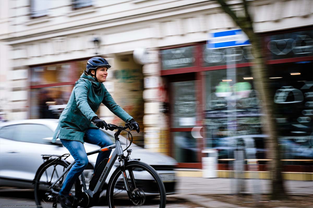 Frau fährt mit einem Fahrrad durch die Stadt