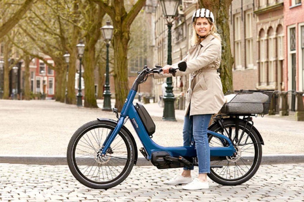 Frau sitzt auf einem blauen E-Bike