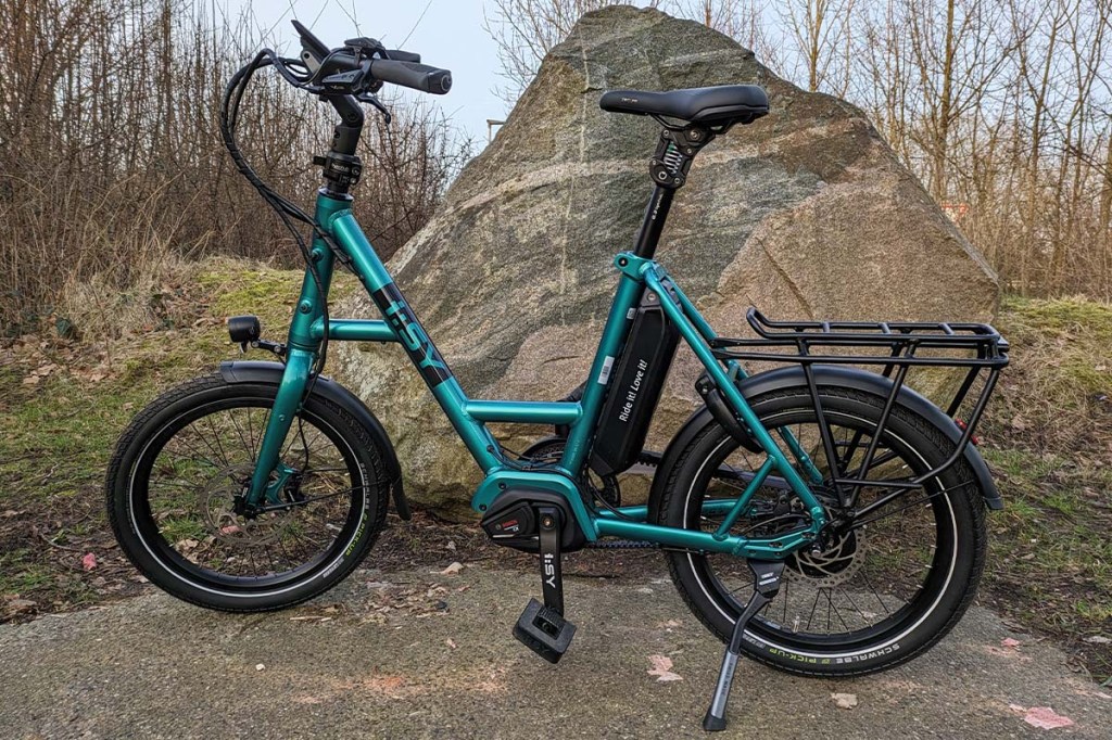grünes Kompakt-E-Bike vor einem Stein stehend