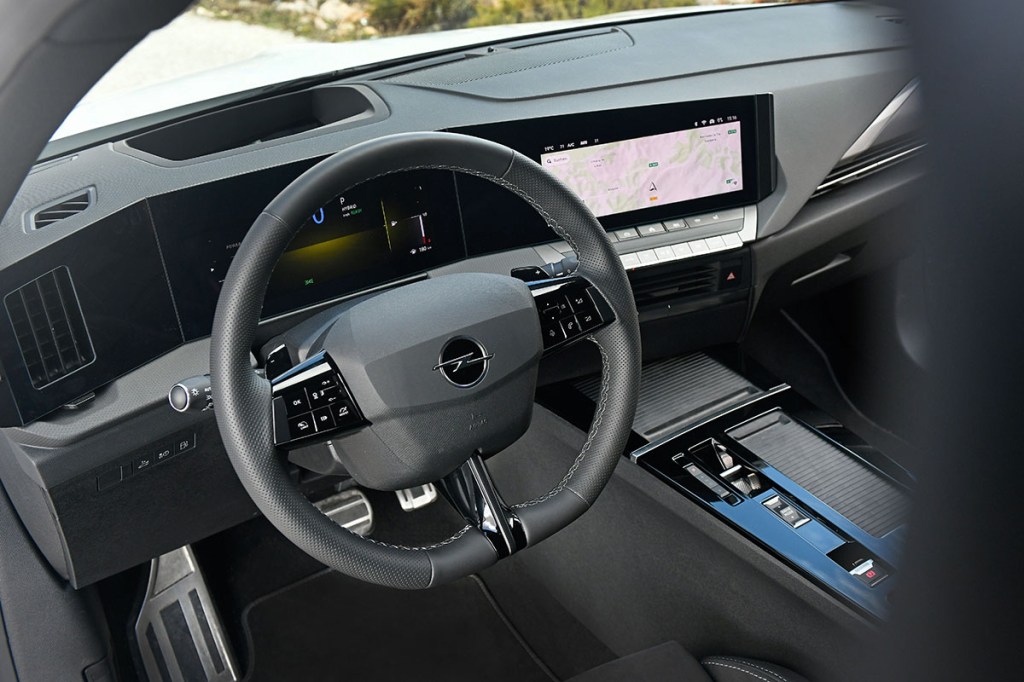 Detailansicht im Cockpit des E-Autos Opel Astra Sports Tourer Electric mit Blick auf das Kenkrad und das Infotainment-Display, das rechts neben dem Lenkrad angebracht ist.