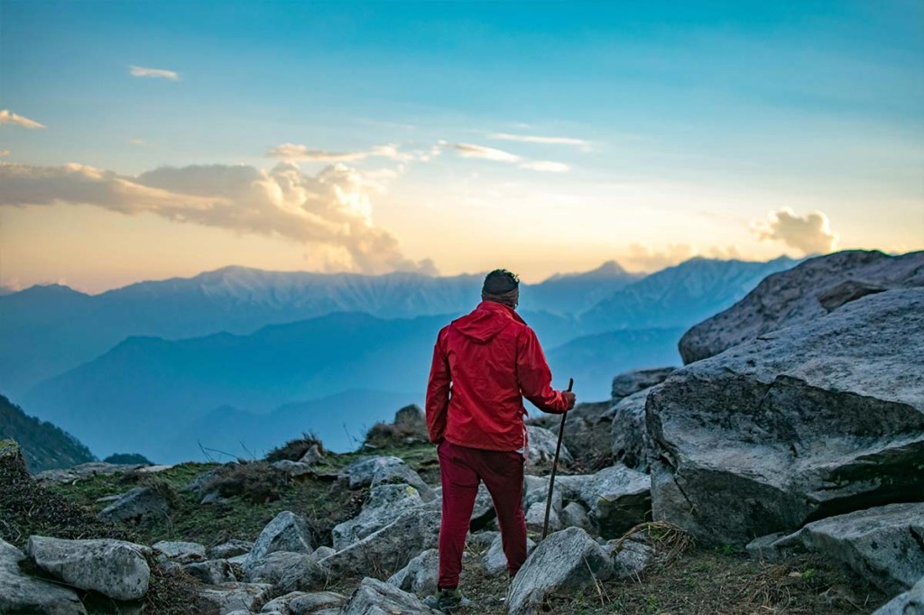 Wanderer in mitten der Natur in den Bergen bei aufgehender Sonne