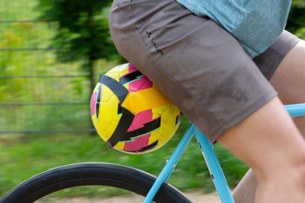 Nahaufnahme eines Balls, der mit einem speziellen Gurt am Fahrradrahmen befestigt ist