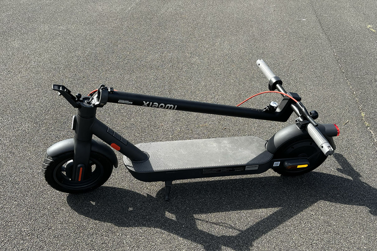 E-Scooter zusammengeklappt auf einer Straße stehende.