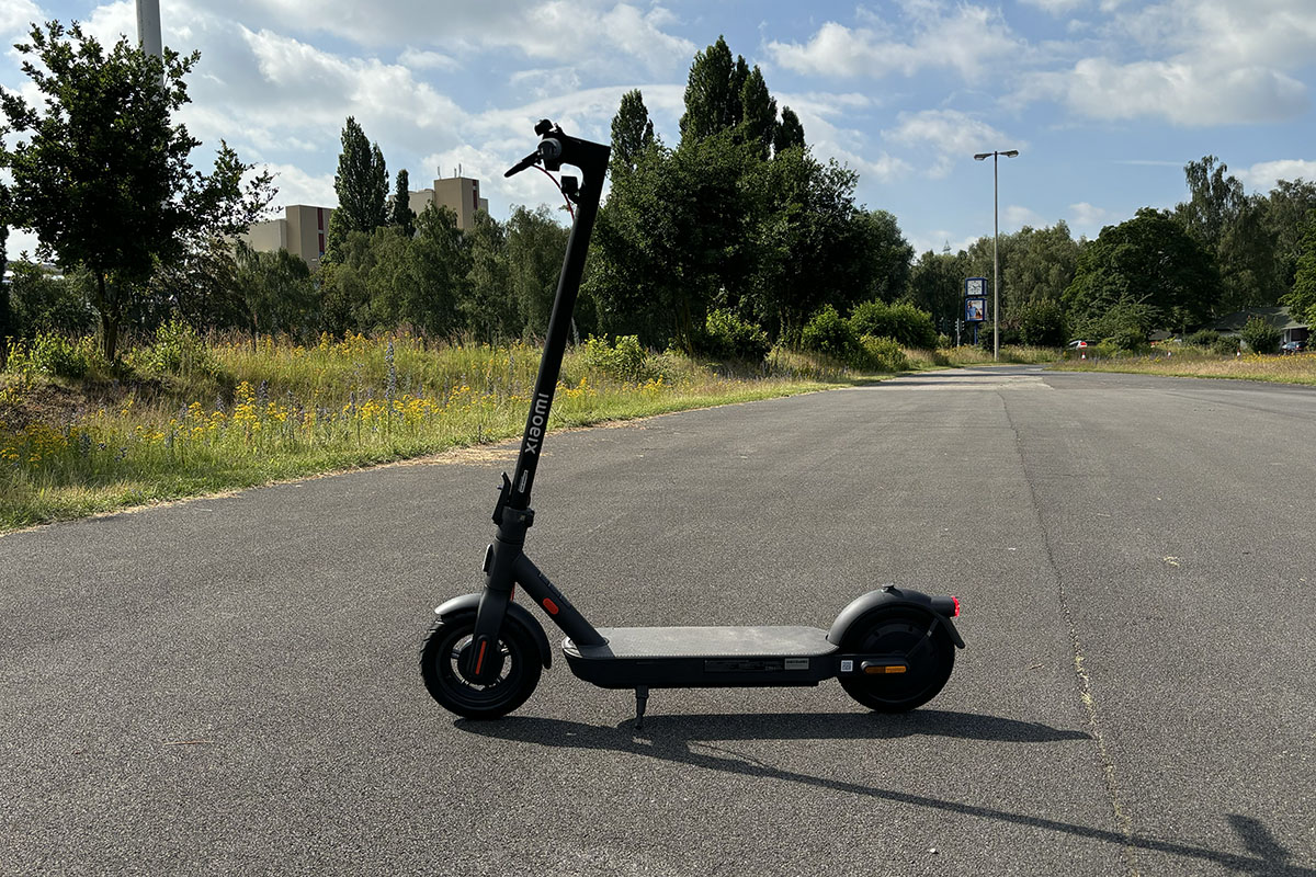 E-Scooter im Profil auf einer Straße stehend.