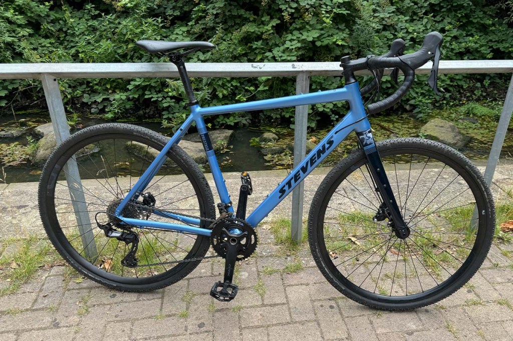 blaues Gravelbike lehnt an einem Bückengeländer