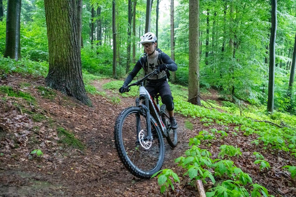 Mann fährt mit seinem Mountainbike durch den Wald