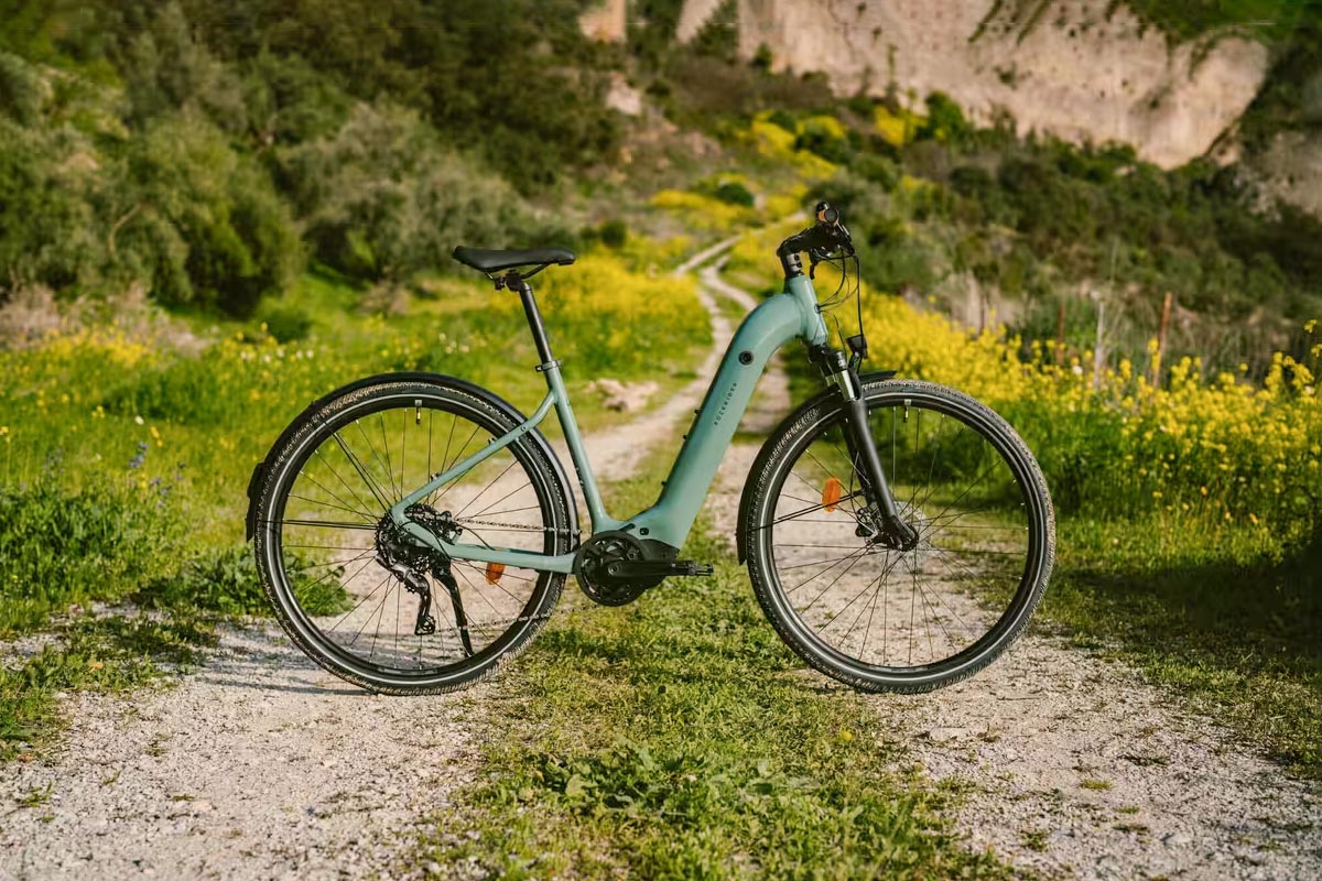 E-Bike von Decathlon auf einem Feldweg unter Sonnenschein.