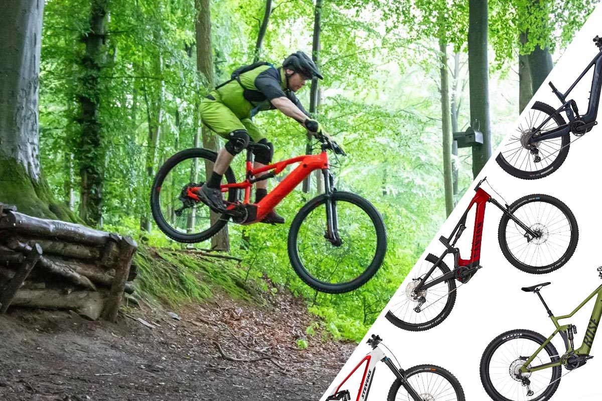 Mann springt mit seinem E-Mountainbike über eine Schanze im Wald