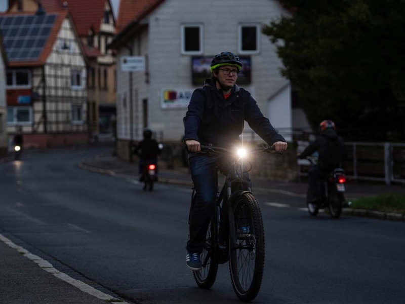 Radfahrer, der in der Dämmerung eine Straße langfährt