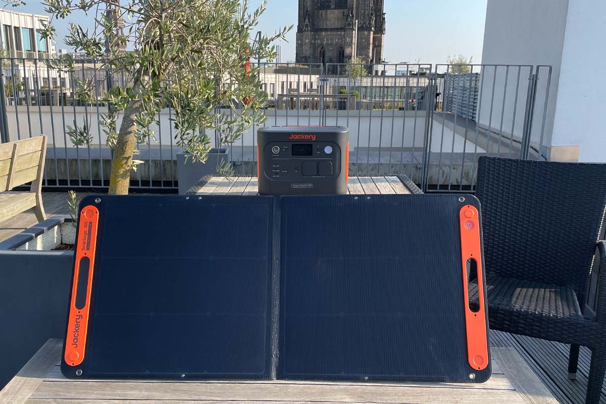 Eine Powerstation und ein Solarpanel von Jackery auf einer Dachterrasse.