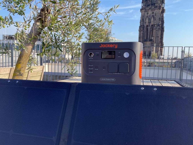 Eine Powerstation und ein Solarpanel von Jackery auf einer Dachterrasse.