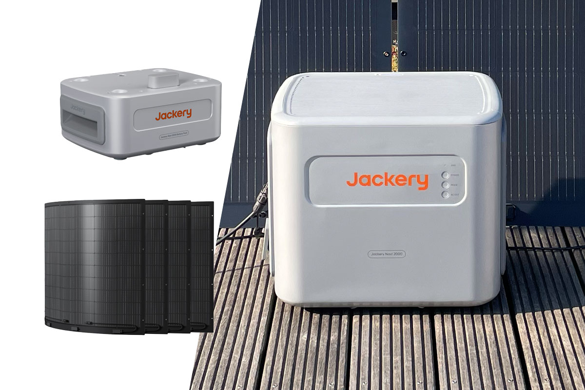 Der Navi 2000 Speicher von Jackery auf Holzplanken mit Solarpanels im Hintergrund. Links zudem flexible Solarpanels und ein Zusatz-Akku auf weißem Grund.