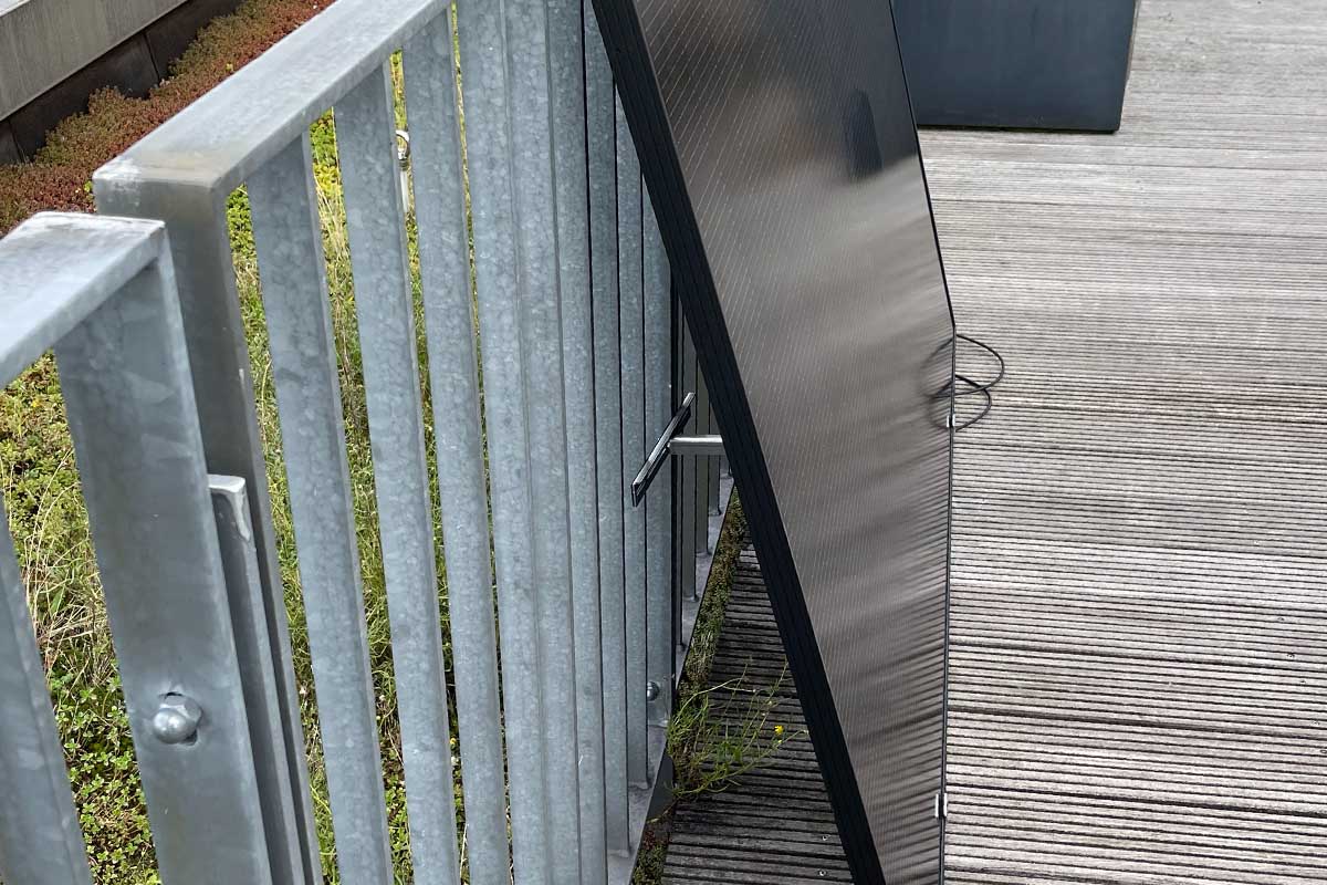 Ein Solarpanel von Kleines Kraftwerk in der Seitenansicht auf einer Dachterrasse.