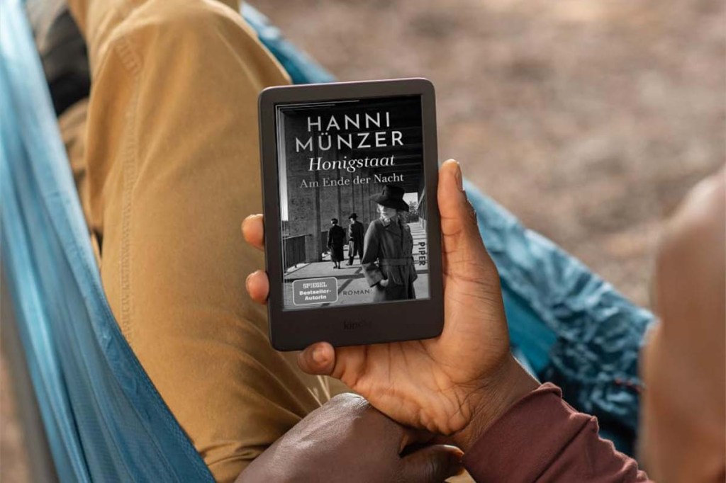 Blick auf einen Amazon Kindle, der von einer Hand festgehalten wird