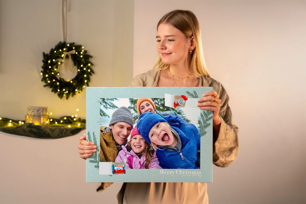 Eine Frau hält einen Foto-Adventskalender in den Händen.