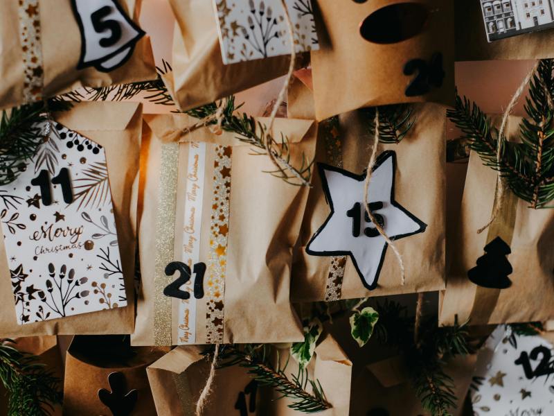 beigefarbene Beutel eines handgemachten Adventskalenders mit Zahlen in Sternchen