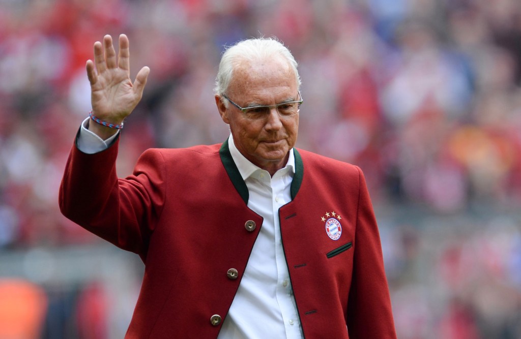 Franz Beckenbauer bei seiner Bayern-Verabschiedung in roter Tracht-Jacke mit Club-Emblem.